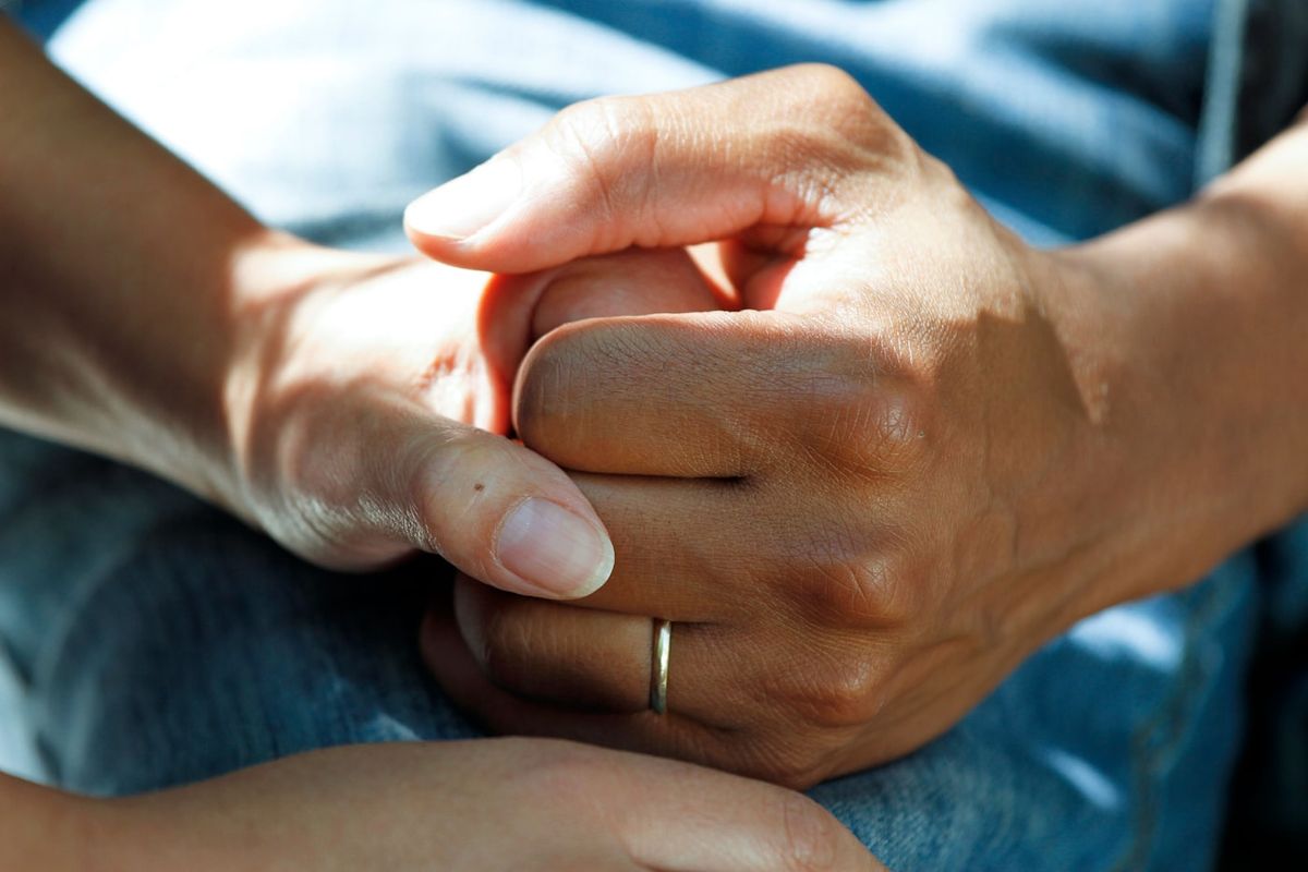 Hand einer Ärztin hält beruhigend die Hand einer Patientin